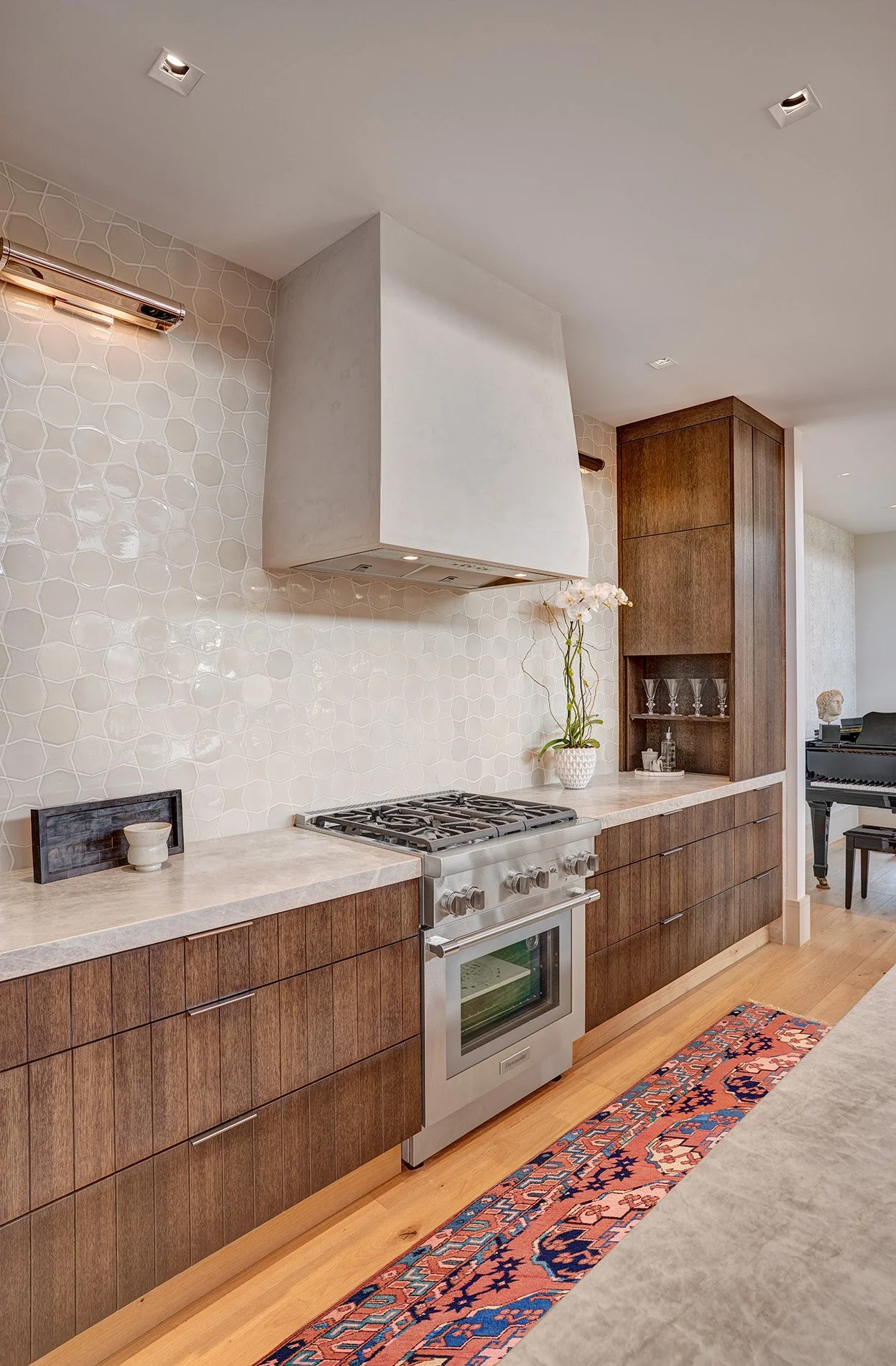 Warm contemporary new construction home, kerf cut kitchen cabinet, plaster hood, tile splash
