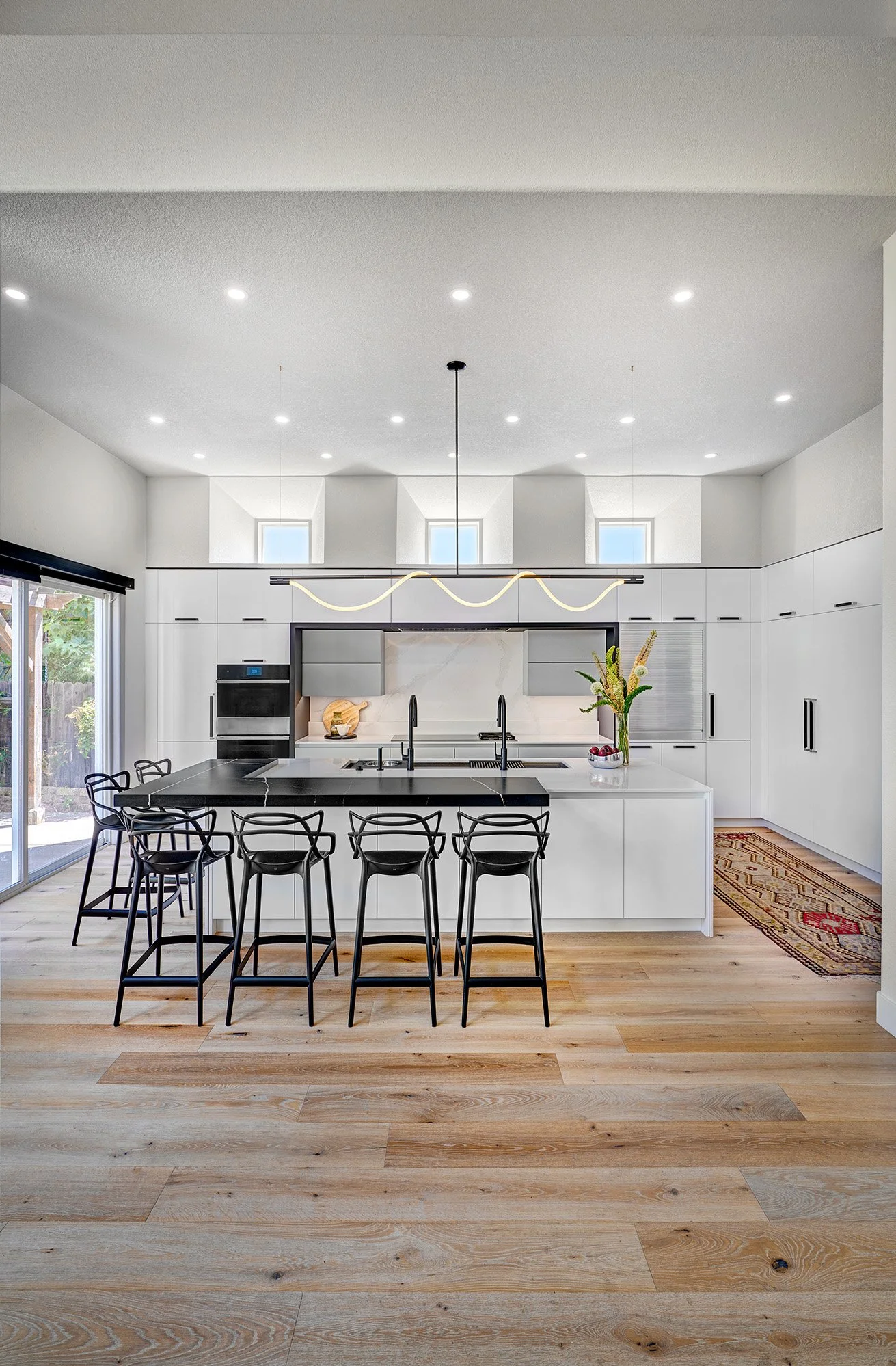Modern kitchen remodel, black + white, large island, European cabinetry, Luke Lamp Co. chandelier