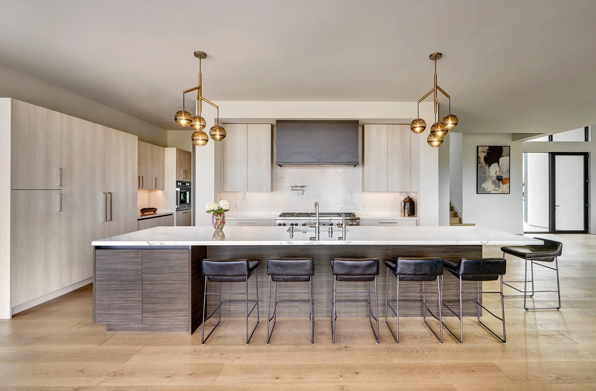 Modern new construction home, European laminate cabinetry, large open kitchen, tall appliance wall, hot rolled steel hood