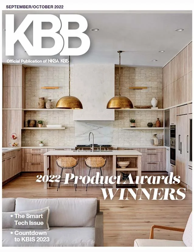 Cover of a magazine featuring a modern kitchen with wooden cabinets, a white kitchen island, and hanging gold pendant lights, with text indicating 2022 Product Awards winners.