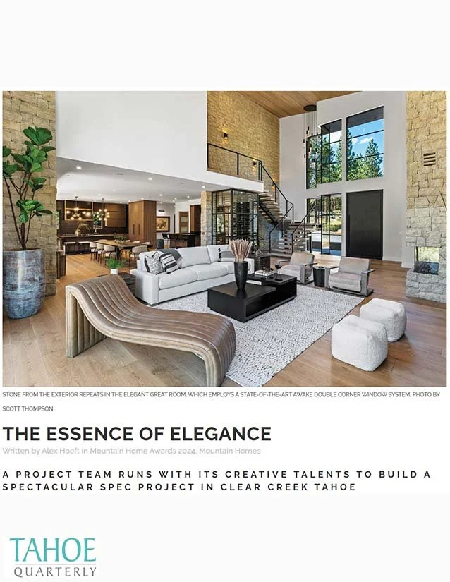 Spacious modern living room with high ceilings, large windows, stone accent walls, white sofa, armchairs, and black coffee table.
